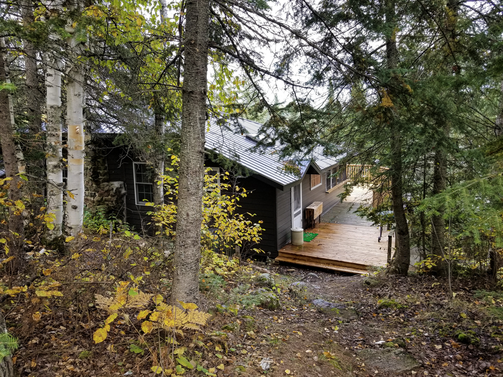 bush view of breezeway to completed outdoor deck with balusters and railings